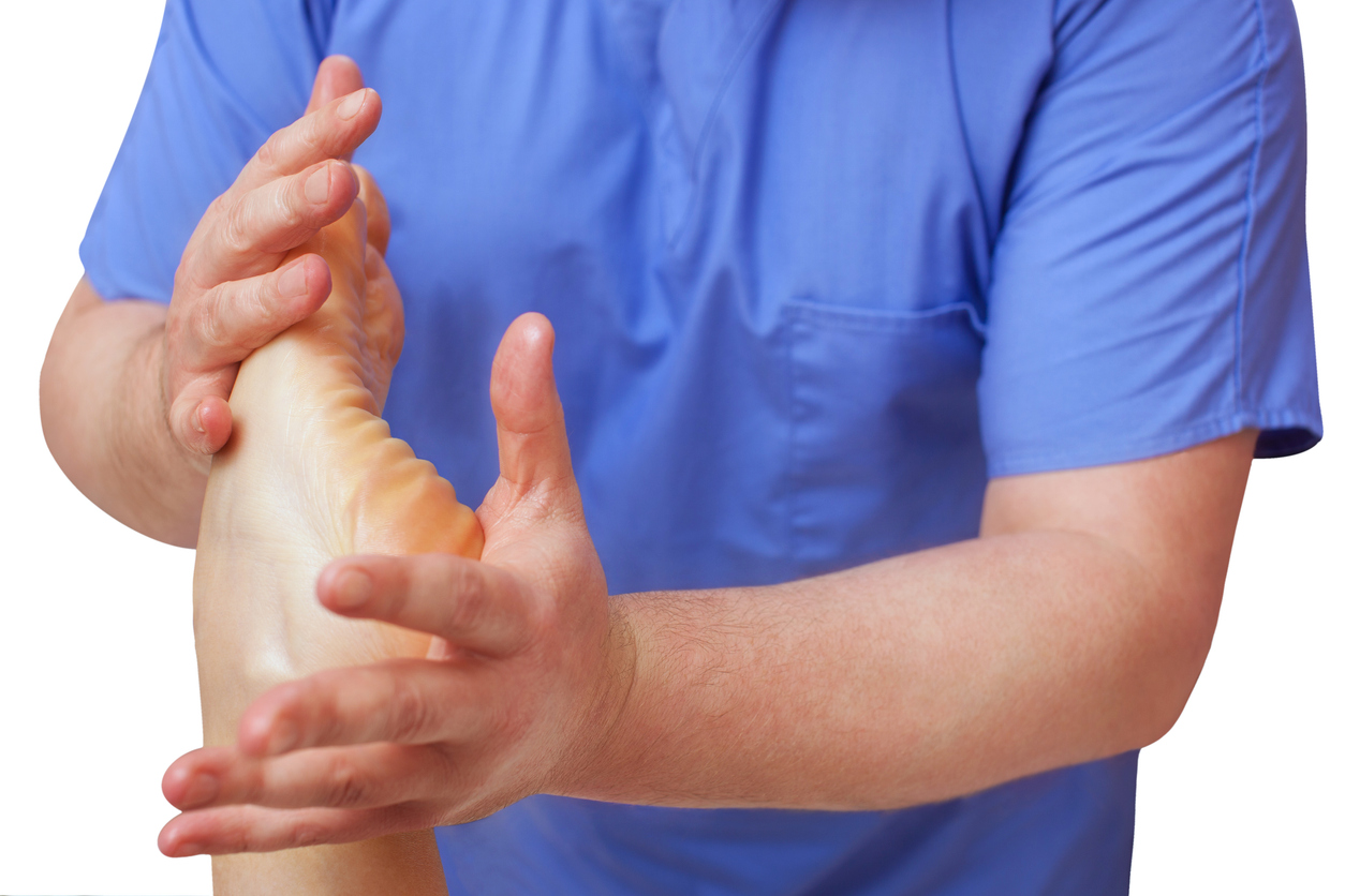 The doctor-podiatrist does an examination and massage of the patient's foot